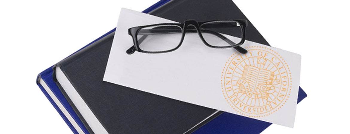An envelope with the UCR seal rests on a stack of books. 